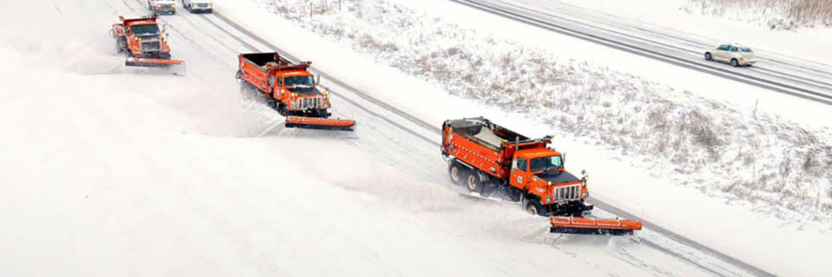 MnDOT plow clearing snow from a roadway.
